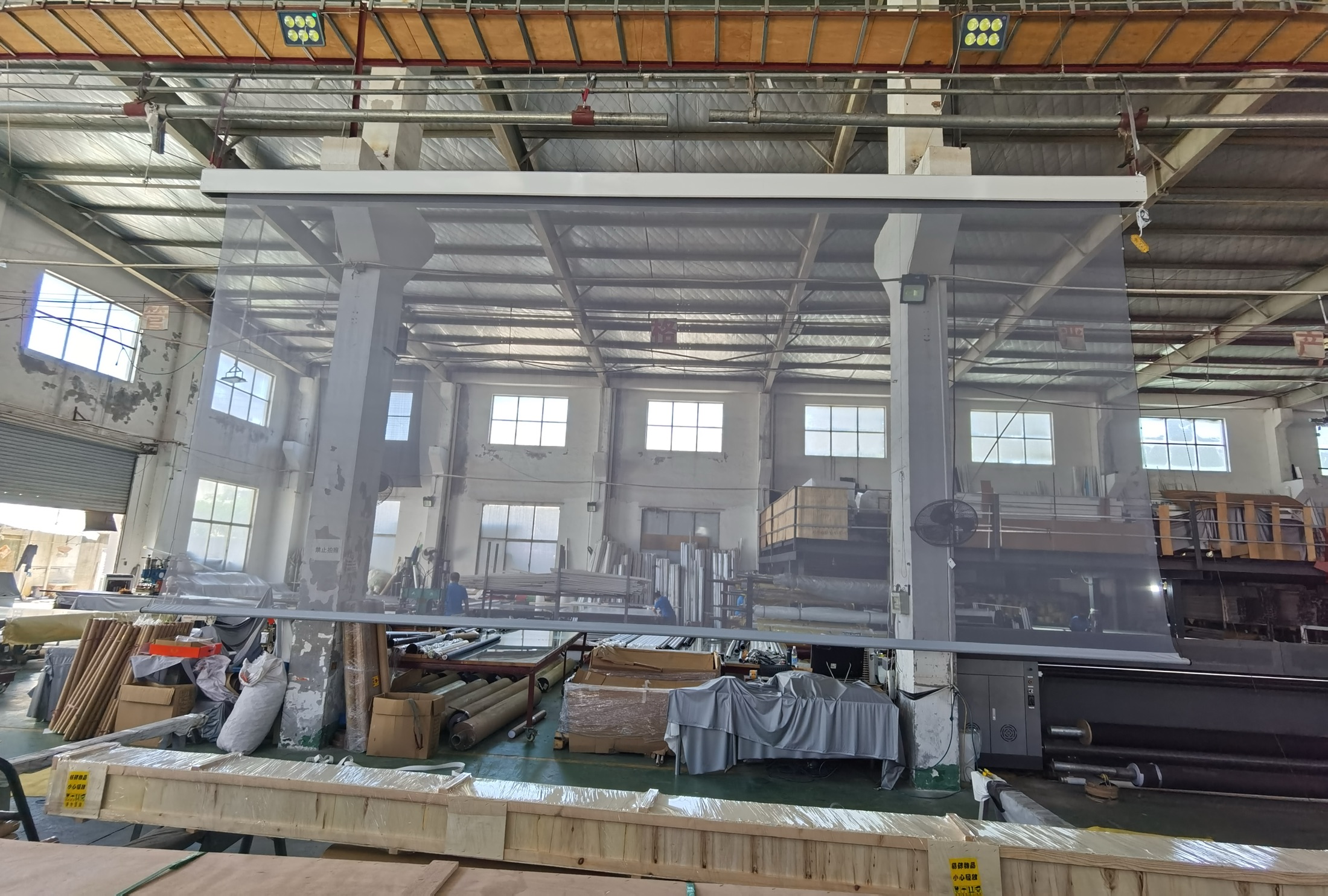 Large-format projection screen extended for inspection inside the iCustom factory