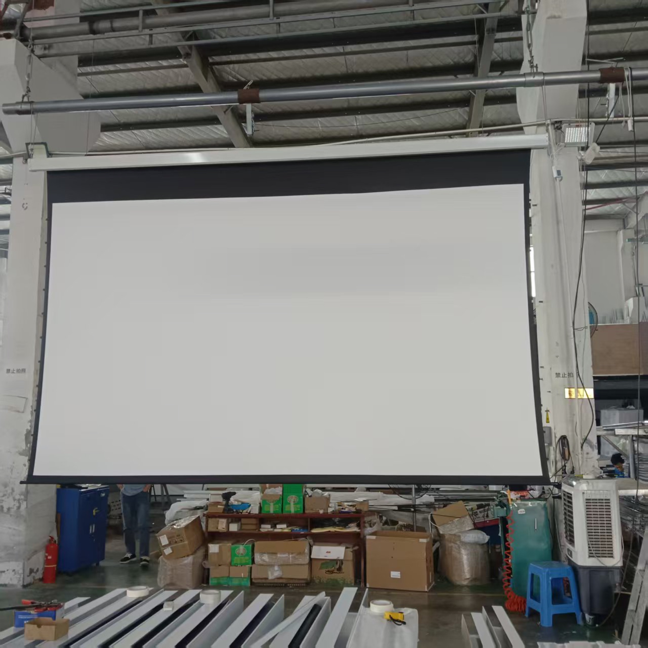 Motorized projection screen fully extended for factory quality control
