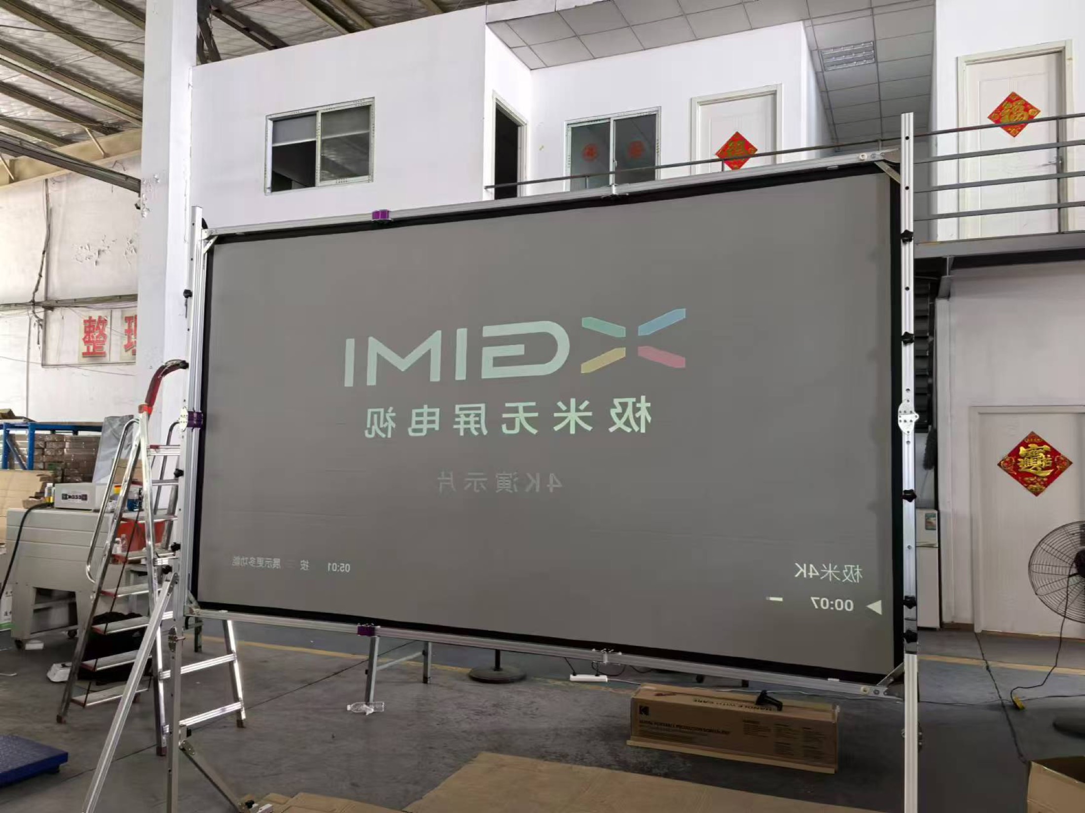 Large fast-fold projection screen undergoing image performance testing in the factory