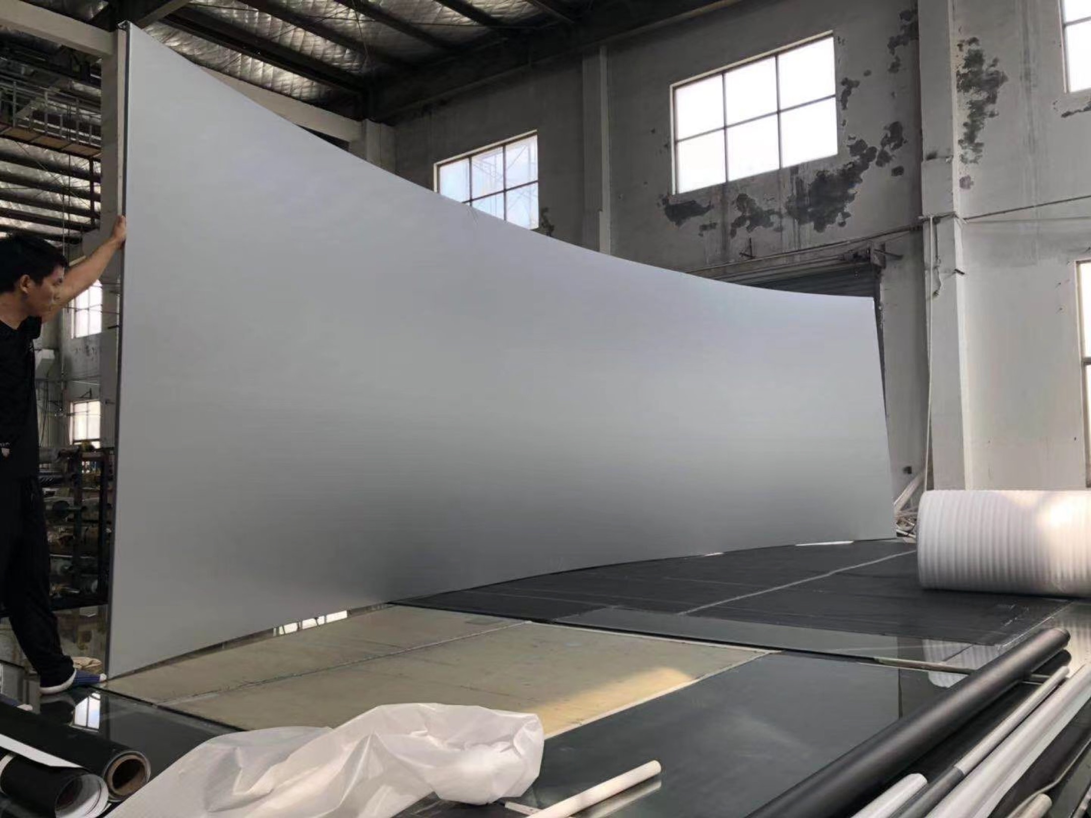 Projection screen material being handled and checked during production